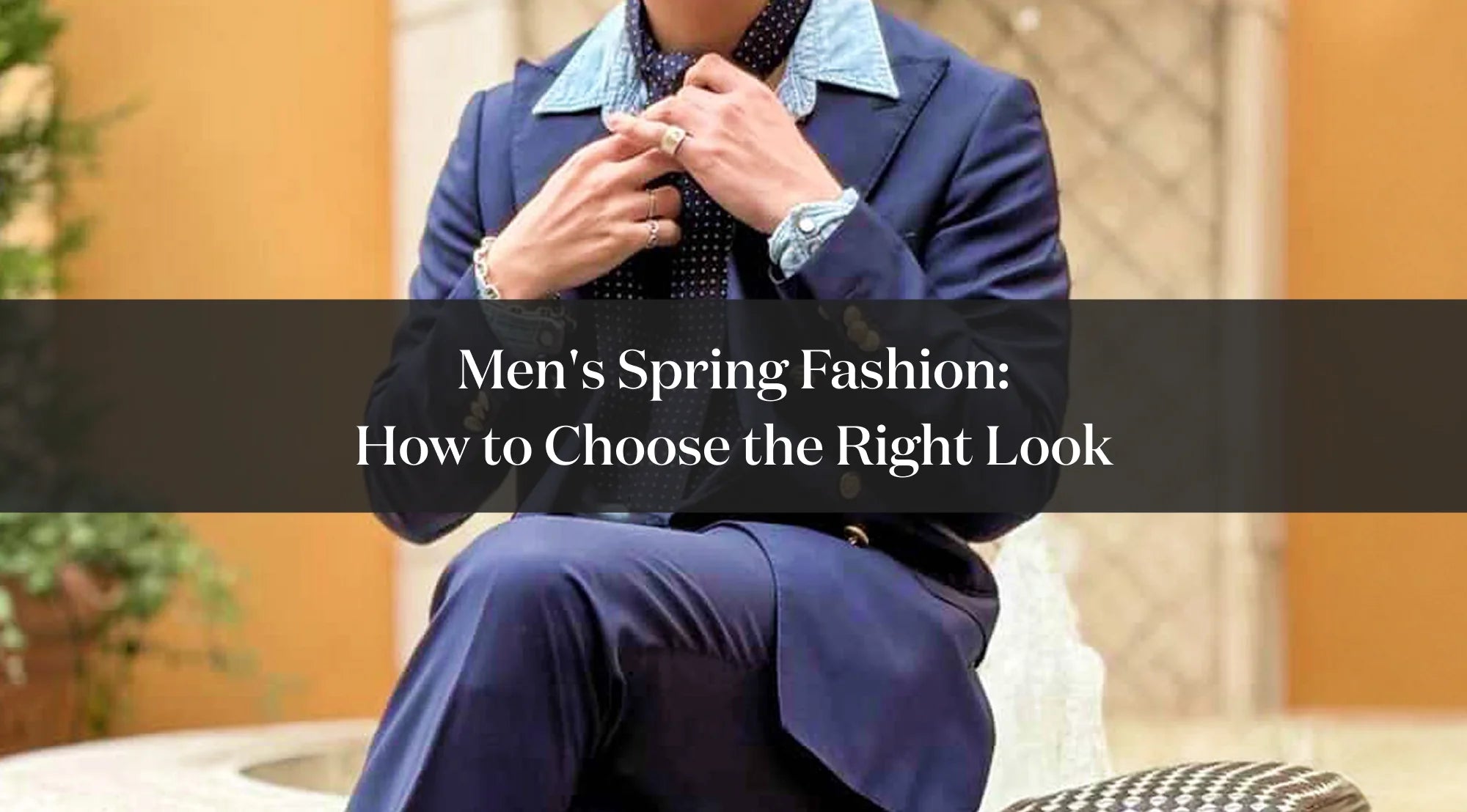 Man in a blue suit sitting and adjusting his tie, with overlaid text reading “Spring men’s fashion: how to choose the right looks”