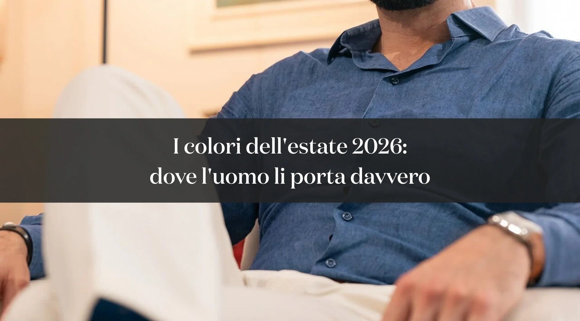 Uomo con camicia azzurra e pantaloni chiari, con testo sui colori dell’estate 2026 nell’abbigliamento maschile.