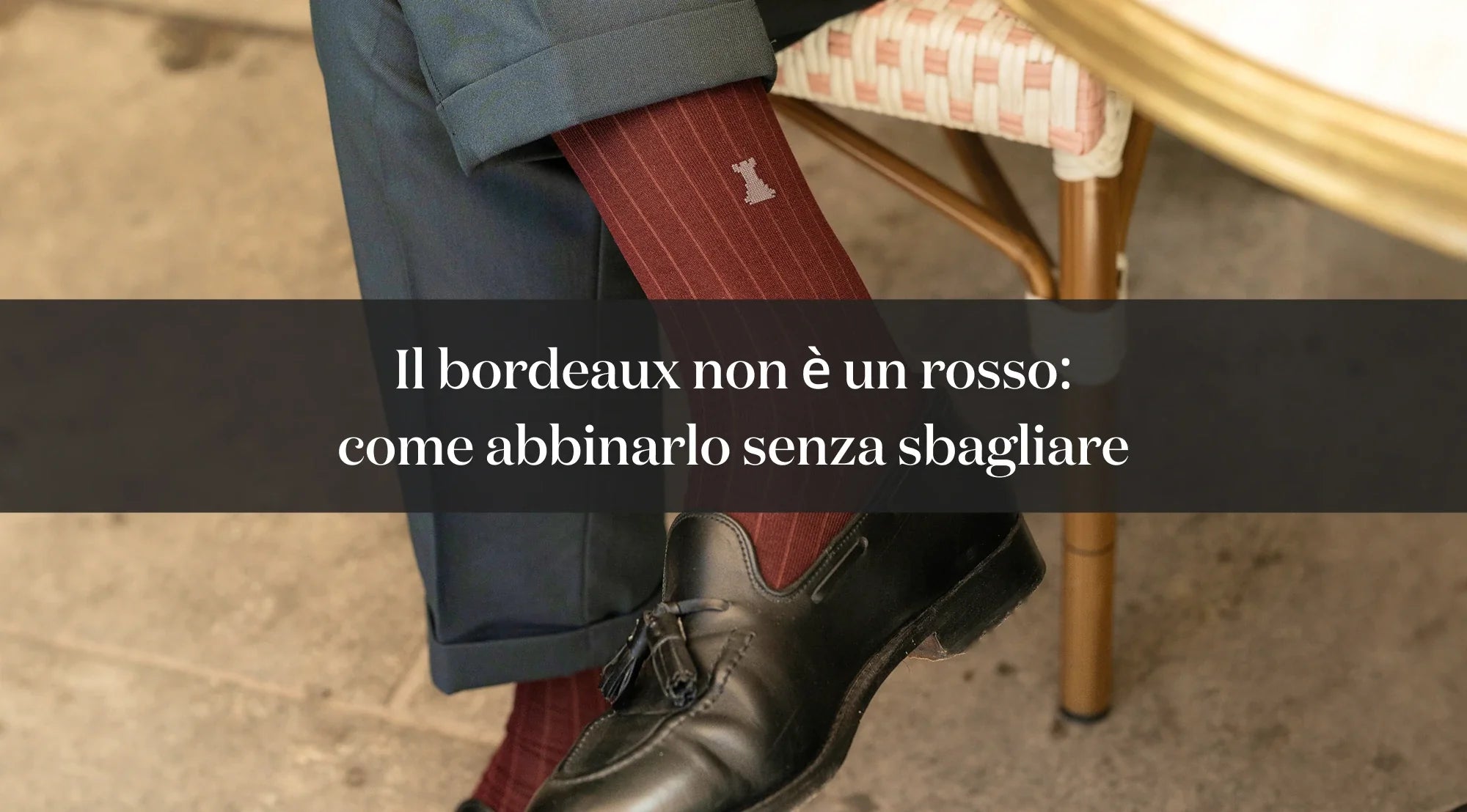 Dettaglio di calza bordeaux indossata con scarpa elegante nera e pantaloni blu, con testo su come abbinare il bordeaux.
