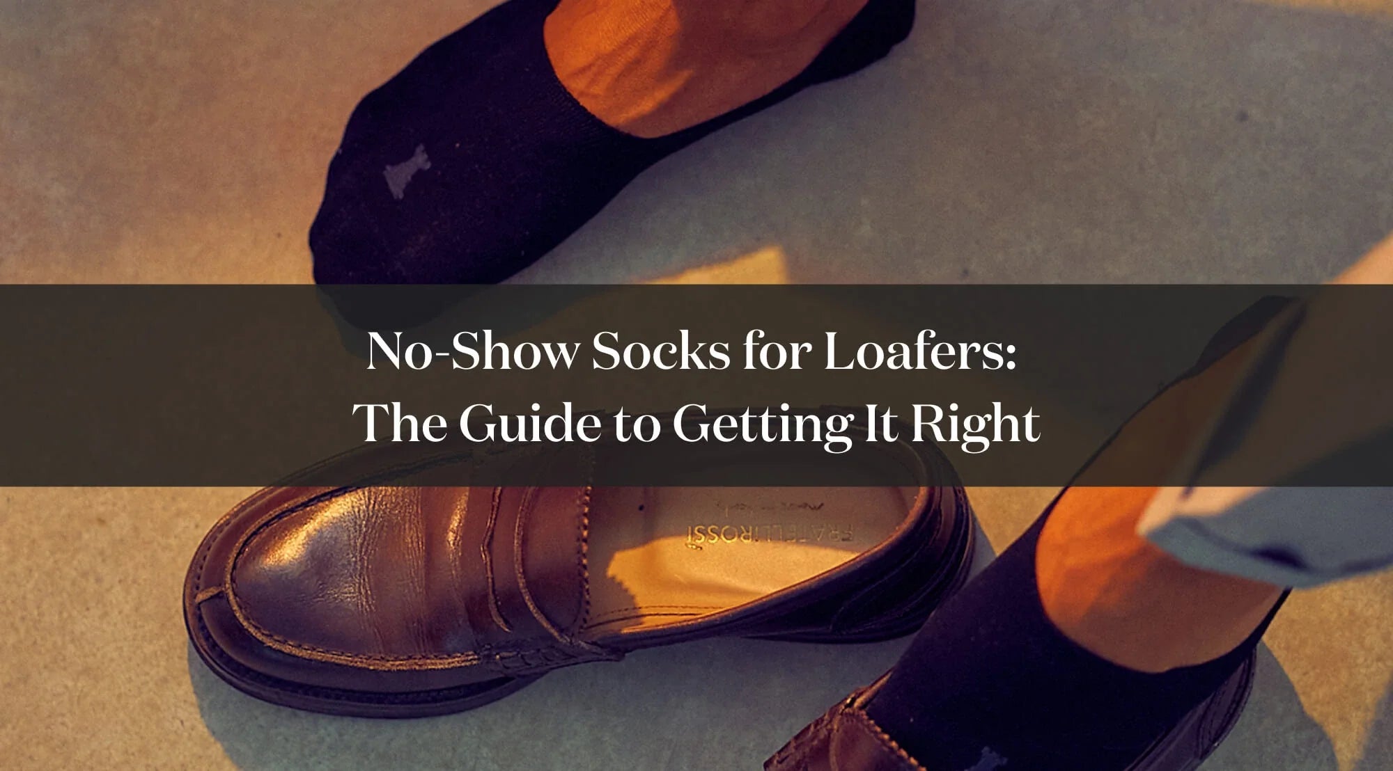Detail of elegant loafers worn with invisible no-show socks and dark trousers.